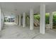 View of parking area and staircase under elevated beach house with concrete slab and white support columns at 215-B S Dogwood Dr., Surfside Beach, SC 29575