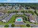 Aerial view of community including pool, pond, parking, landscaping, and surrounding wooded areas with a lake in background at 217 Wando River Rd. # 12-H, Myrtle Beach, SC 29579