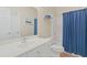 Bathroom with white vanity and toilet along with a shower-tub combination with blue curtains at 217 Wando River Rd. # 12-H, Myrtle Beach, SC 29579