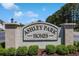 A welcoming entrance sign for Ashley Park Homes, framed by lush landscaping and a clear blue sky at 217 Wando River Rd. # 12-H, Myrtle Beach, SC 29579