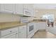 Bright kitchen featuring white cabinets and appliances with light countertops and views to the dining area at 217 Wando River Rd. # 12-H, Myrtle Beach, SC 29579