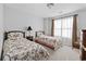 Bright bedroom featuring twin beds with floral bedding, complemented by curtains and a neutral-colored carpet at 2170 Buxton Dr., Myrtle Beach, SC 29579