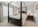 Bedroom featuring a dark four poster bed with white bedding, complemented by two bedside tables and light colored curtains at 2170 Buxton Dr., Myrtle Beach, SC 29579