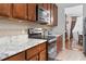 Stylish kitchen featuring dark cabinets, marble countertops, stainless steel appliances, and tile backsplash at 2170 Buxton Dr., Myrtle Beach, SC 29579