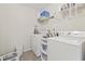 Functional laundry room with a white washer and dryer set, equipped with storage shelves and essential supplies at 2170 Buxton Dr., Myrtle Beach, SC 29579