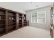 Home office/study room with a built-in bookcase against one wall and a bright window, featuring neutral-colored carpet at 2170 Buxton Dr., Myrtle Beach, SC 29579