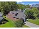 An aerial view showcasing the home's roof, landscaping, and surrounding trees in a lush, green neighborhood at 2302 Clandon Dr., Myrtle Beach, SC 29579