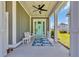 Charming front porch with a turquoise door, ceiling fan, and welcoming bench at 260 Palmetto Harbour Dr., North Myrtle Beach, SC 29582