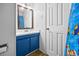 Bathroom featuring a sink with blue cabinets, toilet and mirror, adjacent to a shower at 2701 Hillside Dr. S # 1, North Myrtle Beach, SC 29582