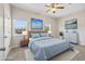 Staged bedroom featuring a neutral palette, ceiling fan, and two bright landscape art pieces at 2701 Hillside Dr. S # 1, North Myrtle Beach, SC 29582