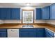 Close-up of a kitchen with blue cabinets, wood counters, and a stainless steel sink at 2701 Hillside Dr. S # 1, North Myrtle Beach, SC 29582