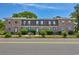 Full street view of brick townhomes, showcasing neat landscaping and symmetrical facades at 2701 Hillside Dr. S # 1, North Myrtle Beach, SC 29582