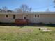 Back view of a home showing a well-maintained lawn and a small deck at 2917 Chippenham Rd., Marion, SC 29571