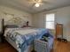 Bedroom with hardwood floors, a comfortable bed with a blue comforter, and natural lighting from the window at 2917 Chippenham Rd., Marion, SC 29571