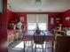 A dining room with red walls, a table with a checkered tablecloth, and a window with blinds at 2917 Chippenham Rd., Marion, SC 29571