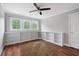 Bright bedroom with hardwood floors, a ceiling fan, three windows, and built-in bookshelves at 2993 Moss Bridge Ln., Myrtle Beach, SC 29579