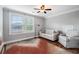 Inviting bedroom with hardwood floors, a ceiling fan, two windows, and a comfy sofa and armchair at 2993 Moss Bridge Ln., Myrtle Beach, SC 29579