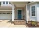 A welcoming entrance with a blue front door, brick steps, and a covered porch with white columns at 2993 Moss Bridge Ln., Myrtle Beach, SC 29579