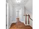 Hallway with hardwood floors, white trim, an open doorway, with stairwell and railing on the right at 2993 Moss Bridge Ln., Myrtle Beach, SC 29579