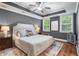 Stylish main bedroom offers natural light, tray ceilings, hardwood floors, and an upholstered headboard at 2993 Moss Bridge Ln., Myrtle Beach, SC 29579
