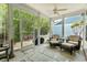 Screened-in porch with ceiling fan, three wicker chairs with ottomans, and views of a wooded backyard at 2993 Moss Bridge Ln., Myrtle Beach, SC 29579