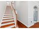 Well-lit staircase with hardwood steps, white risers, and a stained wood handrail leading to upper level at 2993 Moss Bridge Ln., Myrtle Beach, SC 29579