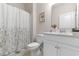 Cozy bathroom with floral shower curtain, white vanity, and neutral tile floor at 315 Cattle Drive Circle, Myrtle Beach, SC 29588
