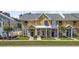 Inviting yellow townhouse featuring a well-manicured lawn and charming front porch at 3550 Pampas Dr. # 2, Myrtle Beach, SC 29577