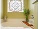 Relaxing bathtub area with decorative window, bamboo plant, and bath caddy at 417 Pennington Loop, Myrtle Beach, SC 29588