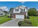 Well-maintained two-story home featuring a brick and vinyl exterior, attached garage, and landscaped front yard near a pond at 417 Pennington Loop, Myrtle Beach, SC 29588