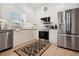 Contemporary kitchen featuring white cabinets, stainless steel appliances, granite counters, and tiled floor at 417 Pennington Loop, Myrtle Beach, SC 29588