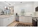 Well-lit kitchen boasts white cabinets, granite countertops, tile backsplash, and stainless steel appliances at 417 Pennington Loop, Myrtle Beach, SC 29588