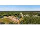 Aerial view showcasing a modern farmhouse with a long driveway surrounded by lush trees and serene landscape at 4426 Still Pond Rd., Conway, SC 29526