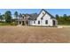 Charming two-story white farmhouse with black trim, showcasing a welcoming front porch and well-manicured landscaping at 4426 Still Pond Rd., Conway, SC 29526