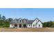 Beautiful white farmhouse exterior with dormers and a manicured front yard at 4426 Still Pond Rd., Conway, SC 29526