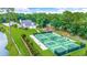 Community aerial view featuring tennis courts, playground, lake, clubhouse, and lush landscaping at 455 Dornoch Dr., Pawleys Island, SC 29585