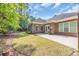 Spacious backyard with a brick home exterior, patio, and a well-maintained lawn at 455 Dornoch Dr., Pawleys Island, SC 29585