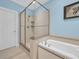 Bright bathroom featuring a soaking tub, walk-in shower, and tile floors at 455 Dornoch Dr., Pawleys Island, SC 29585
