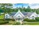 Exterior aerial view of community clubhouse surrounded by lush landscaping and a pond at 455 Dornoch Dr., Pawleys Island, SC 29585