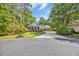 Charming brick home featuring a circular driveway and well-manicured lawn and mature trees at 455 Dornoch Dr., Pawleys Island, SC 29585