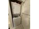 A compact laundry space featuring a stacked washer and dryer next to the bathroom at 4773 Wild Iris Dr. # 301, Myrtle Beach, SC 29577