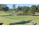 Scenic view of the golf course, featuring mature trees, green fairways, a pond, and a golf cart at 4773 Wild Iris Dr. # 301, Myrtle Beach, SC 29577