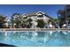 Community pool with lounge chairs, palm trees, and building with balconies in the background on a sunny day at 4773 Wild Iris Dr. # 301, Myrtle Beach, SC 29577