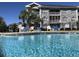Community pool with lounge chairs and building with balconies in the background on a sunny day at 4773 Wild Iris Dr. # 301, Myrtle Beach, SC 29577