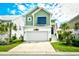 Charming two-story green home featuring a front-facing garage and meticulously landscaped yard with palm trees at 512 Chanted Dr., Murrells Inlet, SC 29576