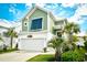 Charming two-story green home featuring a front-facing garage and meticulously landscaped yard with palm trees at 512 Chanted Dr., Murrells Inlet, SC 29576