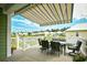 Inviting outdoor patio featuring comfortable seating and a striped awning, overlooking a serene lake and community at 512 Chanted Dr., Murrells Inlet, SC 29576