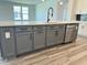 Kitchen island with gray cabinets, hardware, stainless steel dishwasher, and faucet at 543 Oak Landing Dr., Myrtle Beach, SC 29588