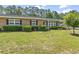 Charming home with well-manicured lawn, lush green bushes, and lovely landscaping at 558 Juniper Dr., Myrtle Beach, SC 29577