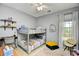 This bedroom has a bunk bed, a desk, and a chair next to a bright window at 5813 Mossy Oaks Dr., North Myrtle Beach, SC 29582